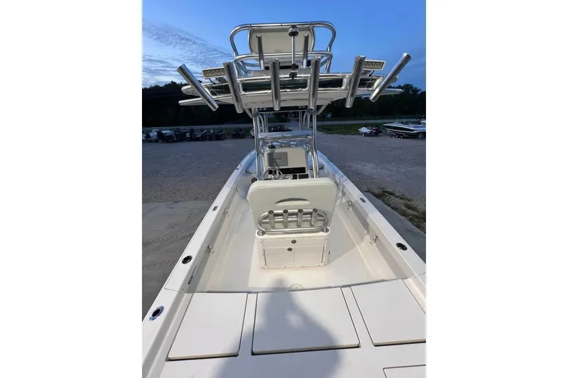 Slide: The Image of 2023 Pathfinder 2600 HPS boat with center console and rod holders, docked at sunset. - 11