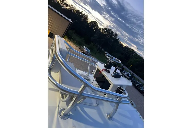 Slide: The Image of 2023 Pathfinder 2600 HPS boat helm with steering wheel and controls at sunset. - 8