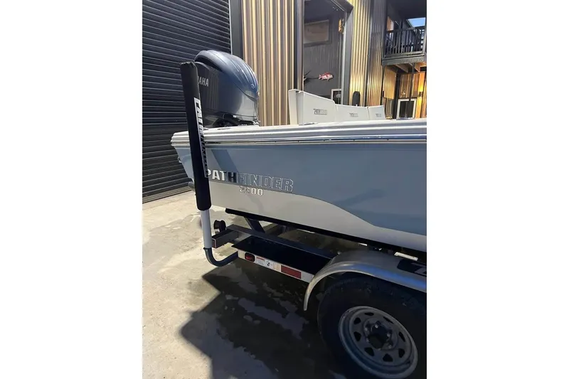Slide: The Image of 2023 Pathfinder 2600 HPS boat on trailer, Yamaha engine, parked near building. - 9
