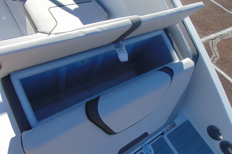 Slide: The Image of 2026 Yamaha Boats AR220 storage compartment with open seat, showcasing interior space. - 7