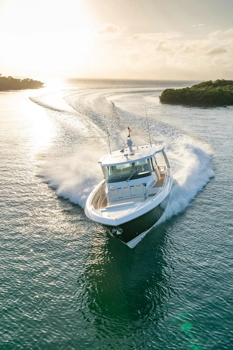 Slide: The Image of 2025 Tiara Yachts 48 LS cruising on serene waters at sunset. - 2