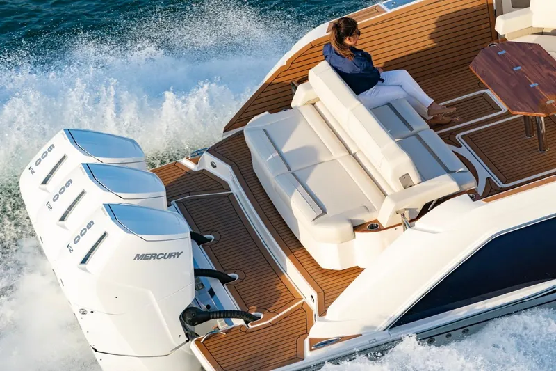 Slide: The Image of 2025 Tiara Yachts 48 LS cruising with powerful Mercury engines, luxury seating, and wooden deck. - 3
