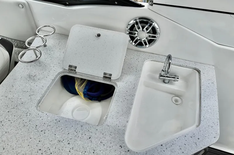 Slide: The Image of 2023 Hurricane Sun Deck 2690 boat interior with sink, storage, and cup holders. - 15