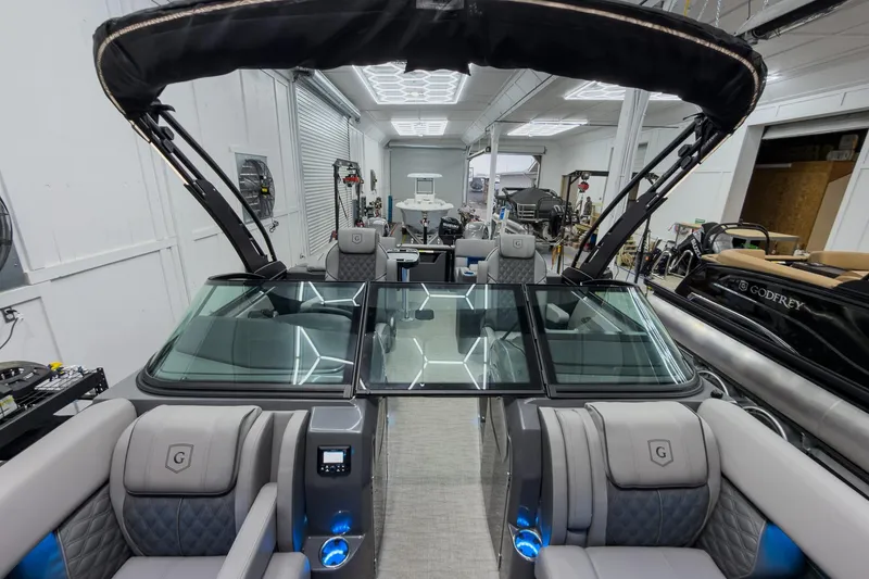 Slide: The Image of 2026 Godfrey Sanpan 27' Tritoon with luxurious seating and modern design in showroom. - 17