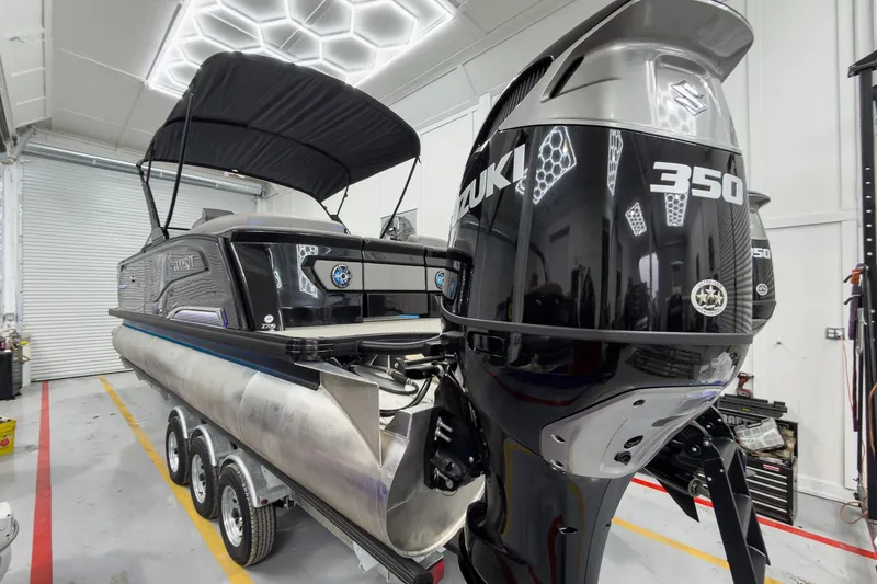 Slide: The Image of 2026 Godfrey Sanpan 27' Tritoon with Suzuki 350 engine in a garage setting. - 6