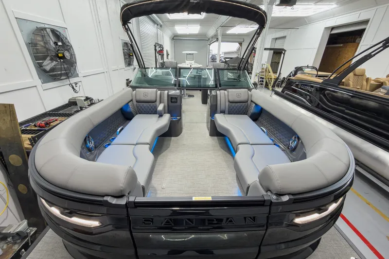 Slide: The Image of 2026 Godfrey Sanpan 27' Tritoon with luxurious seating and modern design in a showroom. - 9