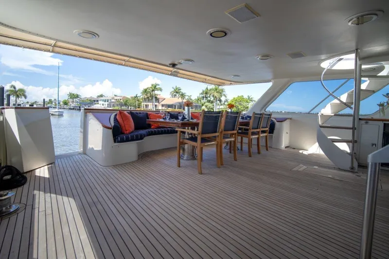 Slide: The Image of Luxurious 1984 Lloyds Ships Tri-Deck yacht with elegant outdoor seating and scenic waterfront view. - 18