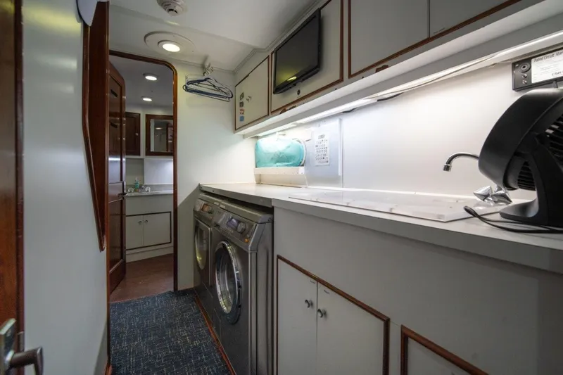 Slide: The Image of Laundry room on 1984 Lloyds Ships Tri-Deck yacht with washer, dryer, and storage cabinets. - 51