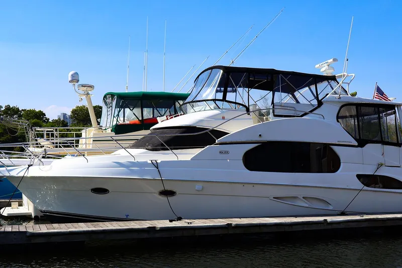 The Image of 2002 Silverton 43 Motor Yacht docked at marina under clear blue sky. - 0