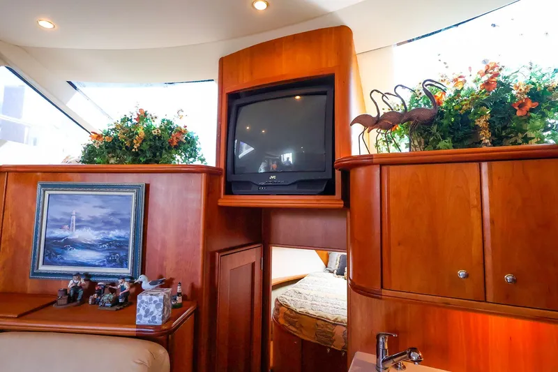 Slide: The Image of Interior of 2002 Silverton 43 Motor Yacht with TV, artwork, and floral decor. - 15