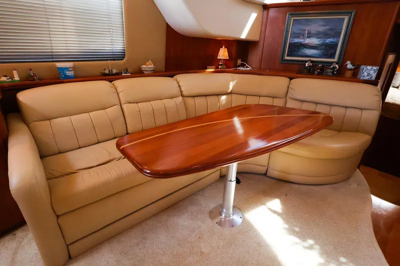 Slide: The Image of Luxurious interior of 2002 Silverton 43 Motor Yacht with plush seating and wooden table. - 16