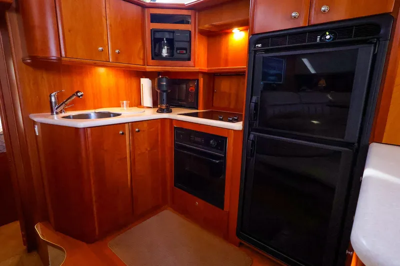 Slide: The Image of 2002 Silverton 43 Motor Yacht kitchen with wood cabinetry, sink, stove, and refrigerator. - 18
