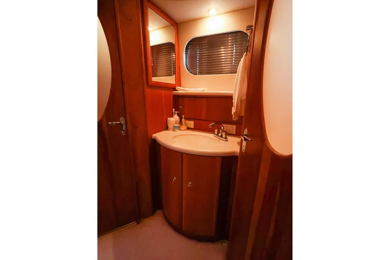 Slide: The Image of 2002 Silverton 43 Motor Yacht bathroom with wooden cabinetry and modern fixtures. - 24