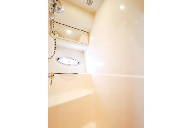 Slide: The Image of Bathroom interior of 2002 Silverton 43 Motor Yacht, featuring shower and porthole window. - 26