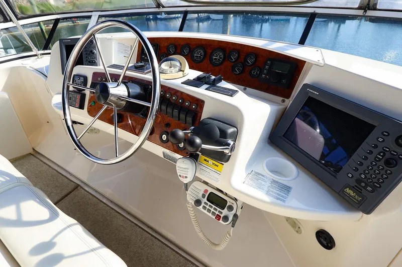 Slide: The Image of 2002 Silverton 43 Motor Yacht helm with steering wheel, controls, and navigation equipment. - 3