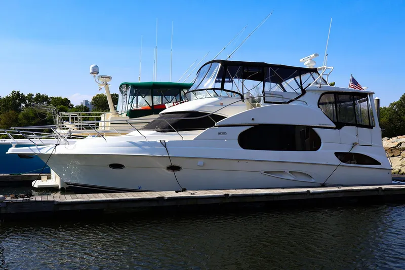 Slide: The Image of 2002 Silverton 43 Motor Yacht docked at marina, clear sky background. - 31
