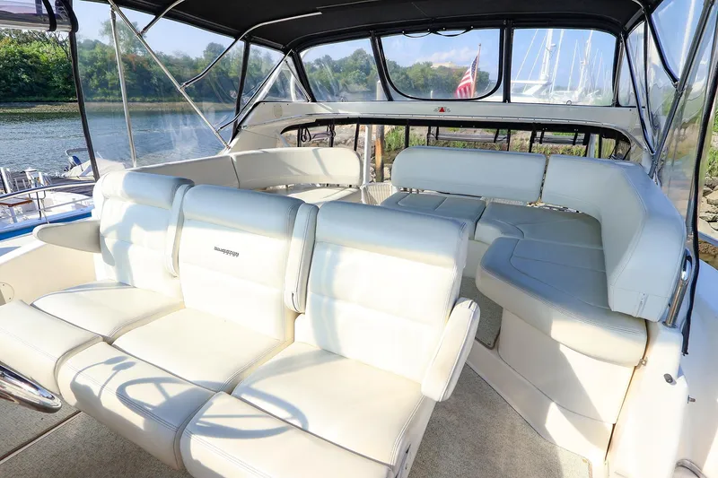 Slide: The Image of 2002 Silverton 43 Motor Yacht interior with white seating and river view. - 4