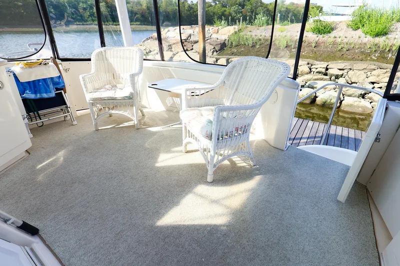 Slide: The Image of 2002 Silverton 43 Motor Yacht interior with wicker chairs and scenic river view. - 5