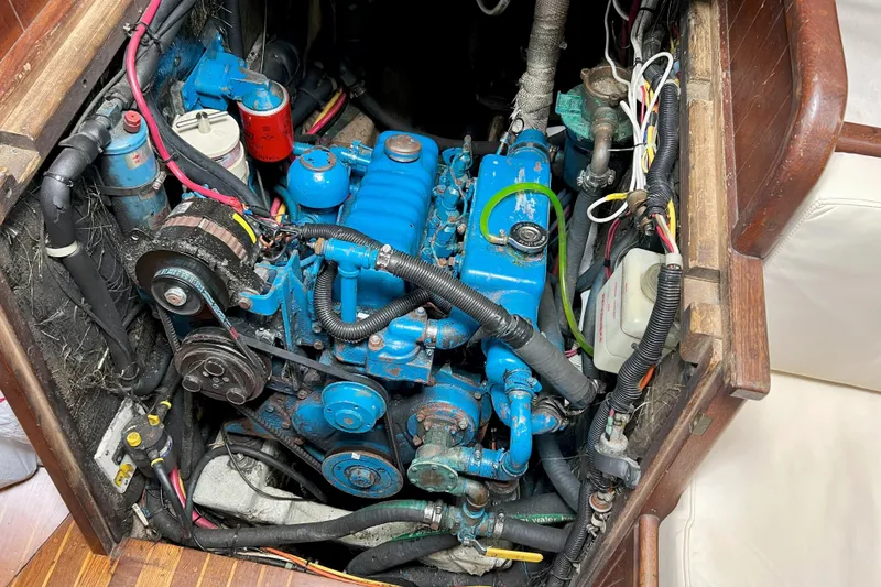 Slide: The Image of Engine compartment of a 1981 Shannon 38 Ketch sailboat, featuring a blue marine engine. - 11