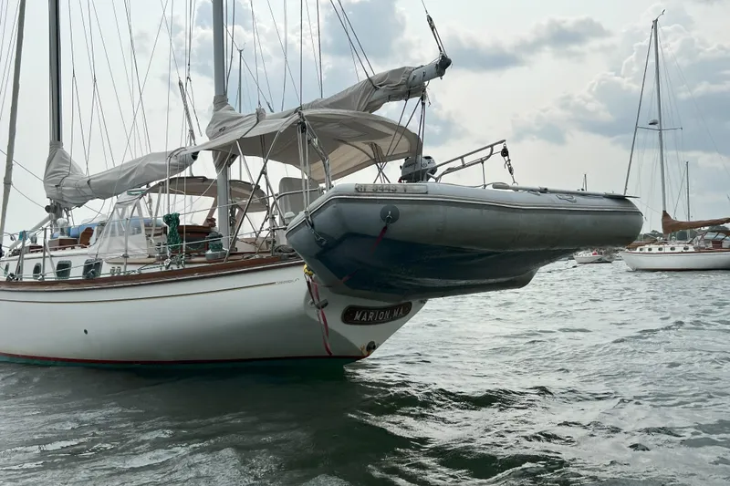 Slide: The Image of 1981 Shannon 38 Ketch sailboat with dinghy, anchored in a calm harbor. - 8