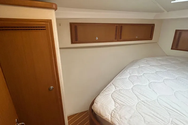 Slide: The Image of 2008 Cabo Yachts Sportfish 35 cabin interior with bed and wooden storage cabinets. - 10