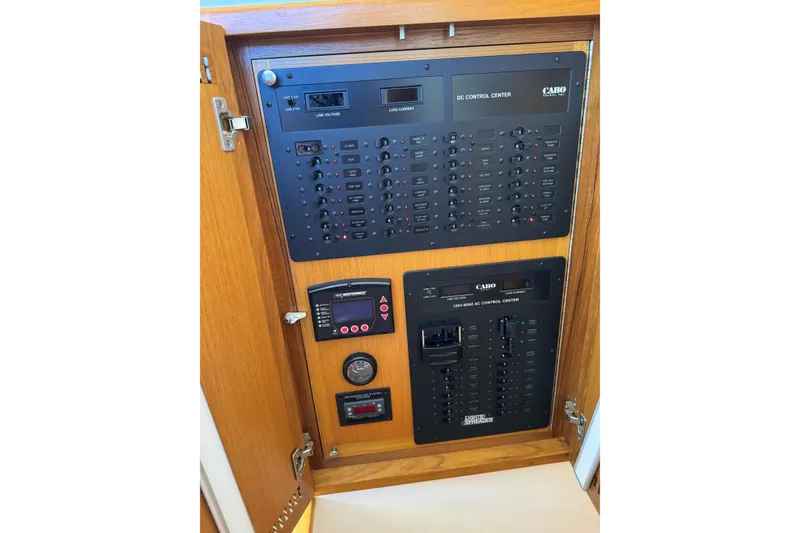 Slide: The Image of Electrical control panel inside 2008 Cabo 35 Flybridge boat, featuring AC and DC systems. - 19