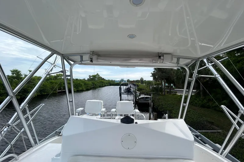 Slide: The Image of 2008 Cabo Yachts Sportfish 35 navigating a scenic waterway with lush greenery. - 6