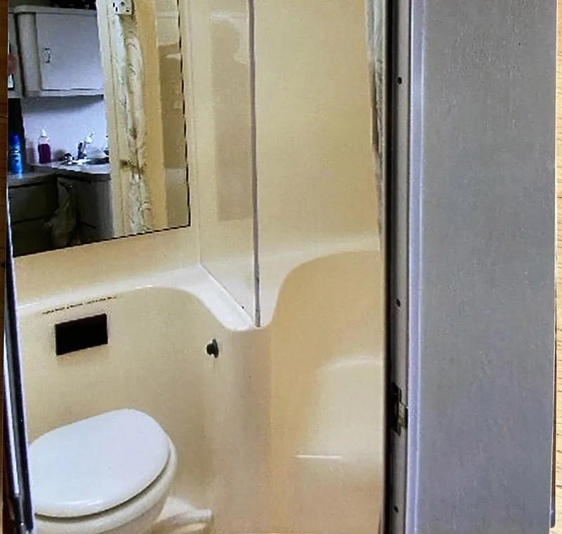 Slide: The Image of 1993 Mainship 36 Express bathroom with toilet, mirror, and compact design. - 10