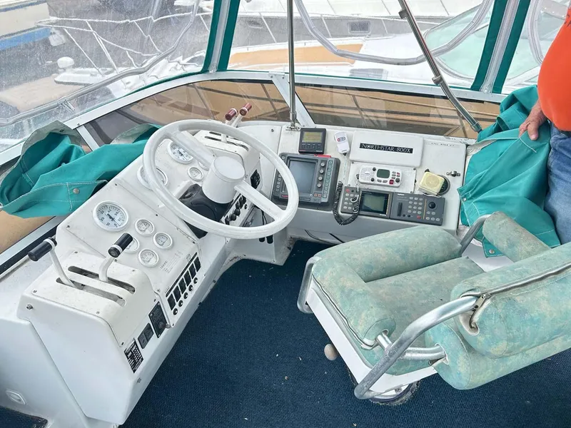 Slide: The Image of Cockpit of 1993 Mainship 36 Express with steering wheel and navigation instruments. - 13