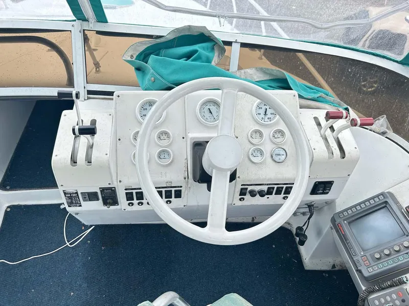 Slide: The Image of 1993 Mainship 36 Express helm with gauges, steering wheel, and navigation equipment. - 14