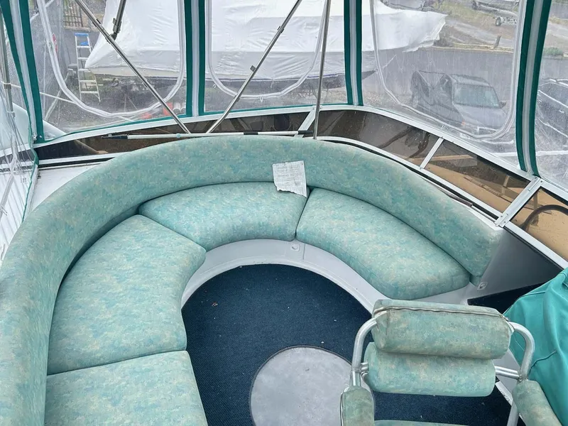 Slide: The Image of 1993 Mainship 36 Express boat interior with curved seating and blue upholstery. - 16