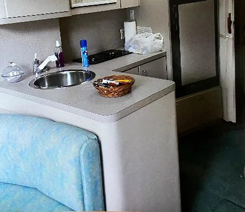 Slide: The Image of 1993 Mainship 36 Express interior kitchen with sink, countertop, and seating area. - 5