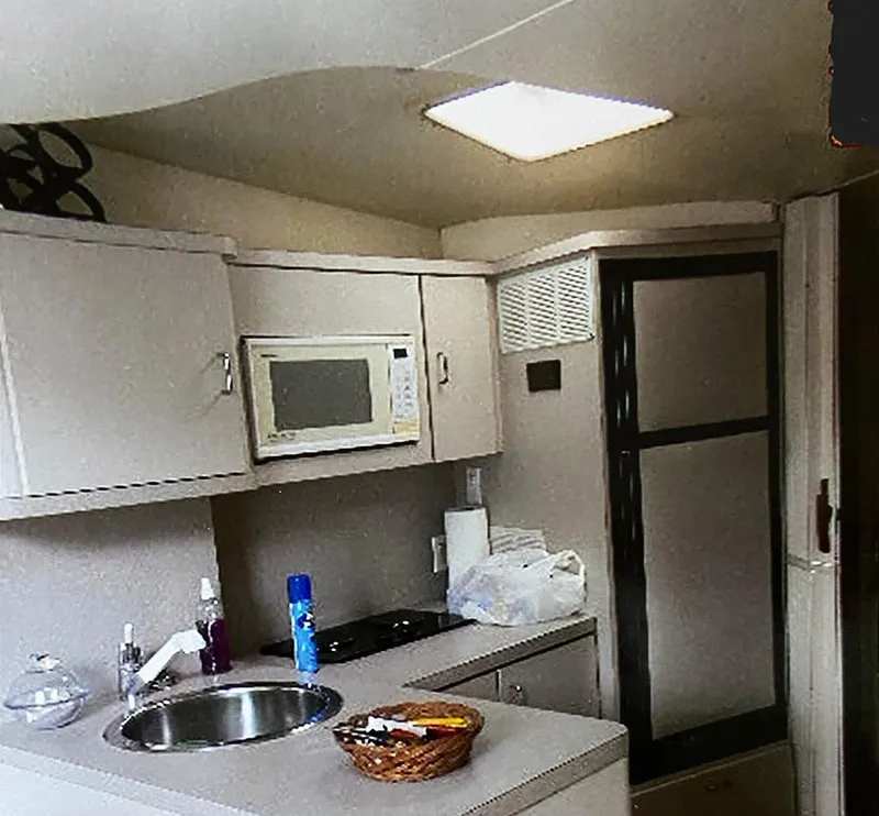 Slide: The Image of 1993 Mainship 36 Express yacht kitchen with microwave, sink, and refrigerator. - 7