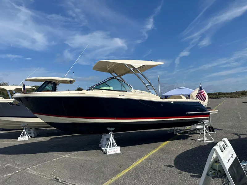 The Image of 2022 Chris-Craft Calypso 24 boat on display under a clear blue sky. - 0