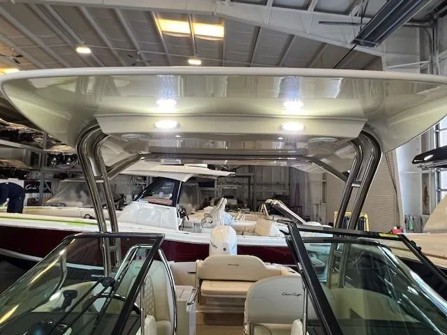 Slide: The Image of 2022 Chris-Craft Calypso 24 boat interior under a canopy in a showroom. - 22
