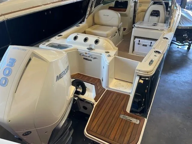 Slide: The Image of 2022 Chris-Craft Calypso 24 boat with Mercury 300 outboard engine, teak flooring, and spacious seating. - 6