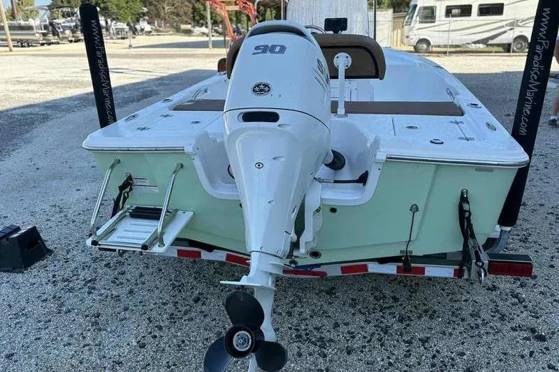 Slide: The Image of 2024 Sea Pro 172 Bay boat with outboard motor on trailer, parked outdoors. - 14