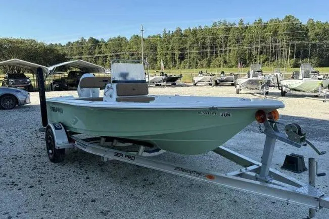 Slide: The Image of 2024 Sea Pro 172 Bay boat on trailer, parked outdoors with trees in background. - 4