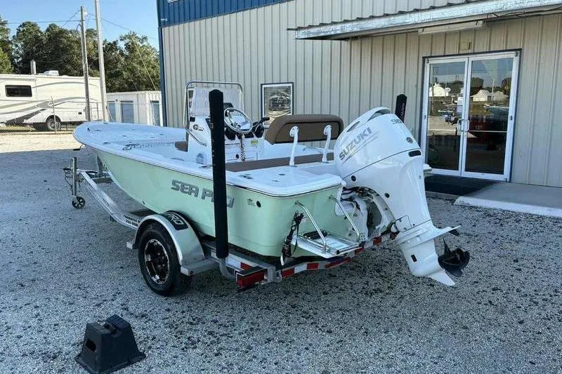 Slide: The Image of 2024 Sea Pro 172 Bay boat with Suzuki outboard motor on trailer, parked outside a building. - 9