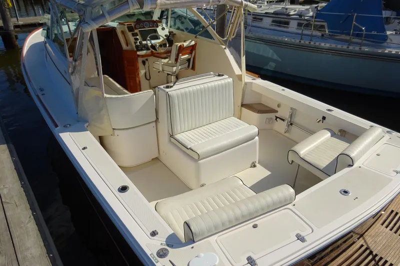 Slide: The Image of 2007 Hunt Yachts Surfhunter 29 with white seating and wooden dashboard, docked at marina. - 10
