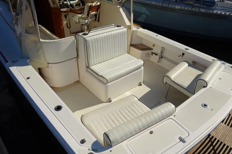 Slide: The Image of 2007 Hunt Yachts Surfhunter 29 interior with white cushioned seating and wooden accents. - 12
