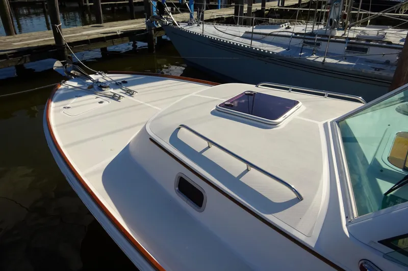 Slide: The Image of 2007 Hunt Yachts Surfhunter 29 docked, showcasing sleek deck design and hatch. - 18