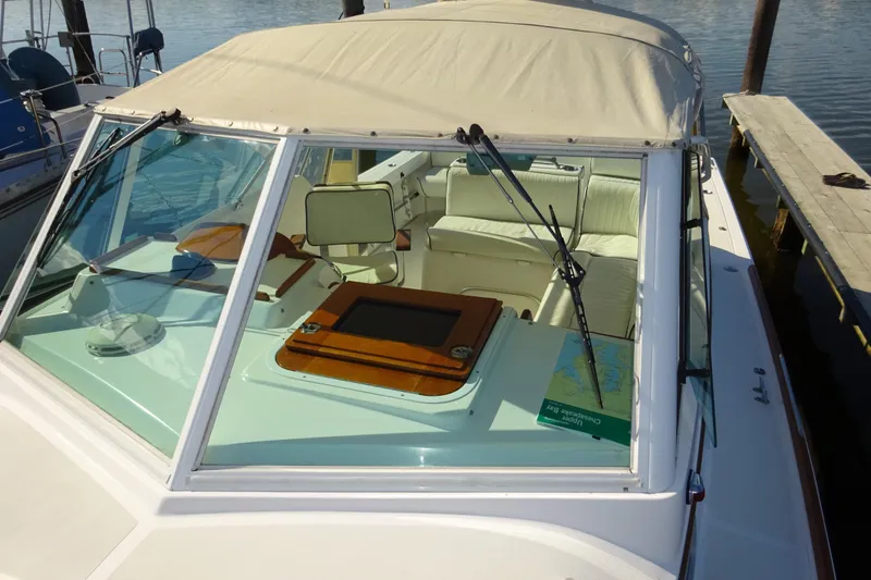 Slide: The Image of 2007 Hunt Yachts Surfhunter 29 with beige canopy and white interior, docked by the water. - 19