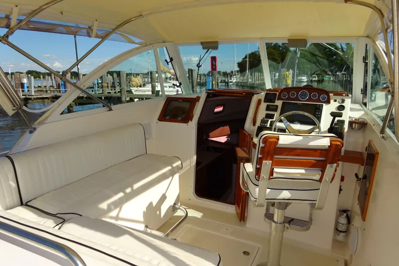 Slide: The Image of 2007 Hunt Yachts Surfhunter 29 interior with helm, seating, and marina view. - 32