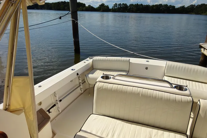 Slide: The Image of 2007 Hunt Yachts Surfhunter 29 interior with white seating, docked by a serene lake. - 35