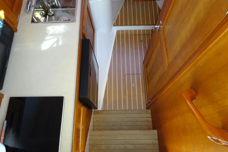 Slide: The Image of 2007 Hunt Yachts Surfhunter 29 interior with wooden flooring and compact kitchen area. - 44