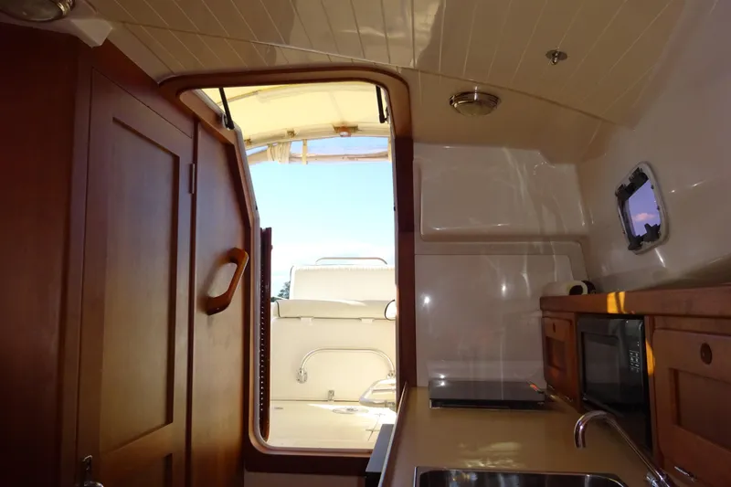 Slide: The Image of Interior view of 2007 Hunt Yachts Surfhunter 29, featuring kitchenette and wooden cabinetry. - 48