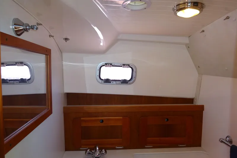 Slide: The Image of 2007 Hunt Yachts Surfhunter 29 interior with wooden cabinetry and porthole window. - 50