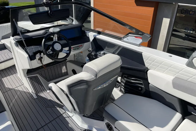 Slide: The Image of 2023 Nautique Super Air Nautique G25 boat interior with modern steering and seating. - 6