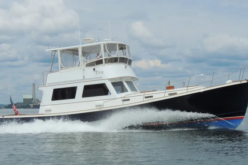 The Image of 1987 Jarvis Newman Downeast Flybridge cruising on water, showcasing sleek design and performance. - 0